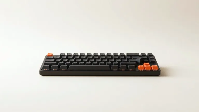 Teclado mecánico negro con una tecla sin su capuchón; debajo asoma el vástago naranja.